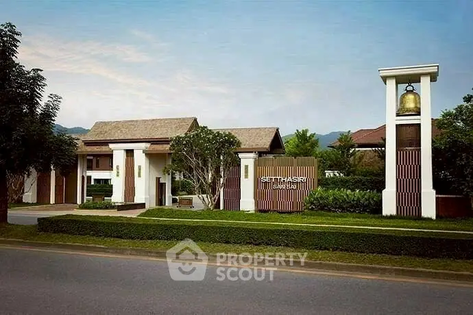 Elegant entrance of a luxury residential community with lush greenery and modern architecture.