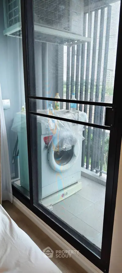 Modern apartment balcony with washing machine and city view