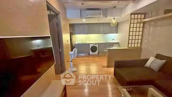 Modern living room with open kitchen and washing machine in stylish apartment.