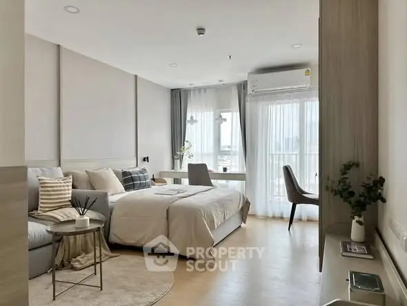 Modern bedroom with cozy decor and natural light, featuring a stylish workspace.