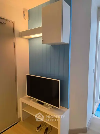 Modern interior with sleek TV setup and stylish blue accent wall in a cozy living space.