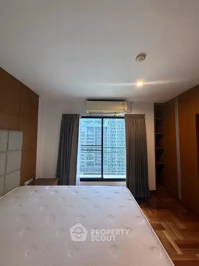 Spacious bedroom with city view and elegant wooden flooring