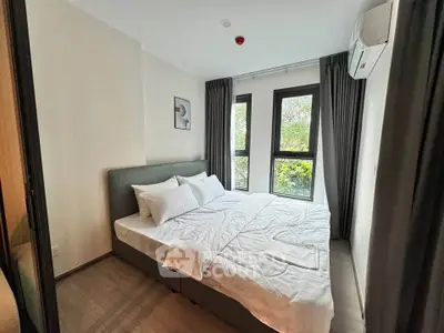 Cozy bedroom with large windows and modern decor, perfect for relaxation.