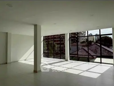 Spacious modern living room with large windows and abundant natural light.