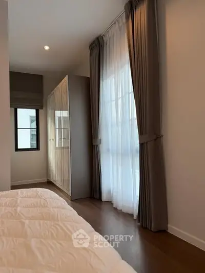 Cozy bedroom with elegant curtains and ample natural light