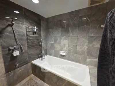 Luxurious bathroom with elegant marble tiles and modern bathtub.