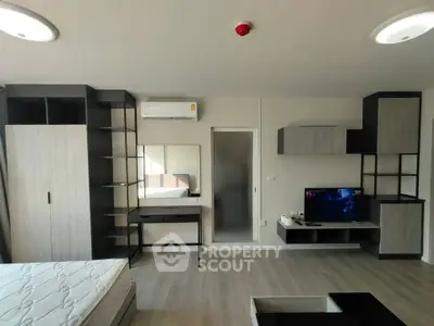 Modern studio apartment with sleek furniture and TV setup, ideal for urban living.