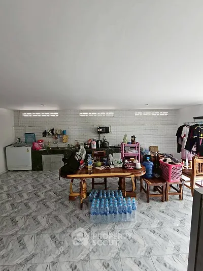 Spacious kitchen with tiled floor and ample storage, featuring modern appliances and dining area.