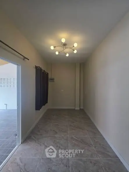 Spacious interior room with modern lighting and tiled flooring, ideal for versatile use.