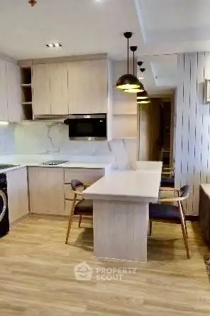 Modern kitchen with sleek wooden cabinetry and integrated appliances in a stylish apartment.
