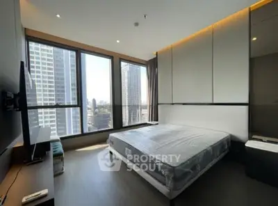 Modern bedroom with large windows and city view in high-rise apartment