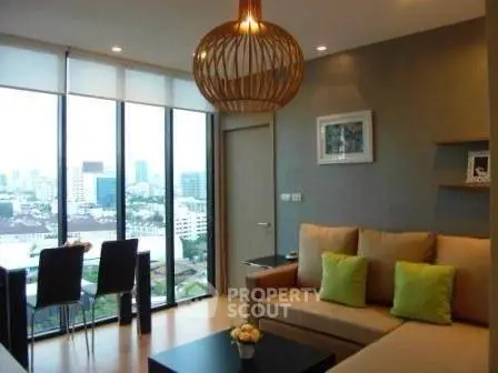 Modern living room with city view, stylish lighting, and cozy seating area.
