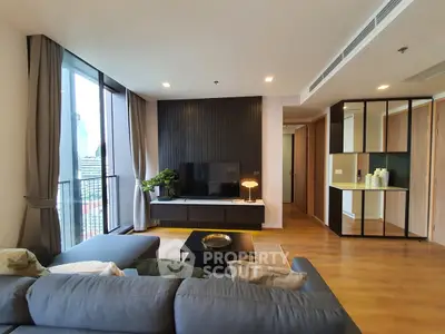 Modern living room with large windows and stylish decor in a high-rise apartment.