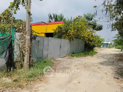 Charming rural property with vibrant yellow building and lush greenery