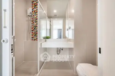 Modern bathroom with sleek design and colorful tile accent in a contemporary home.