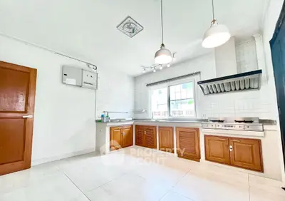 Spacious kitchen with modern gas stove and ample storage in a bright, airy setting.