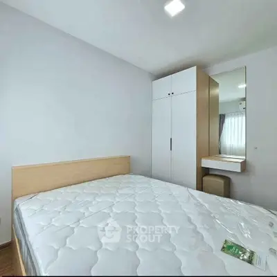 Modern bedroom with minimalist design featuring a comfortable bed and sleek wardrobe.