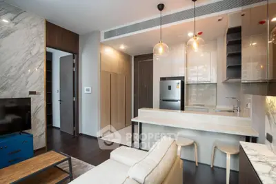 Modern open-layout kitchen and living room with stylish decor and marble accents.