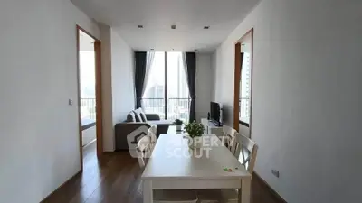 Modern open-plan living and dining area with large windows and city view.