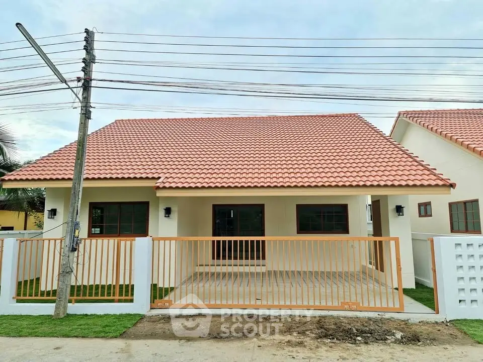 Charming single-story house with red-tiled roof and gated front yard.