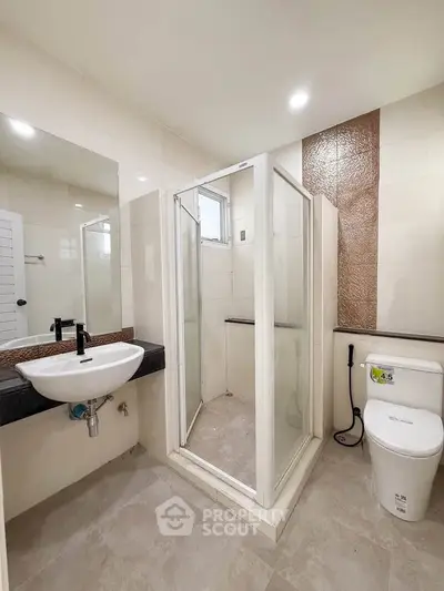 Modern bathroom with glass shower enclosure and sleek fixtures