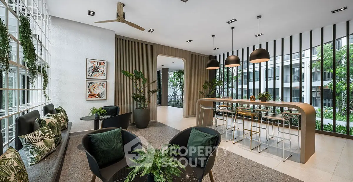 Modern living room with stylish decor and large windows overlooking greenery.
