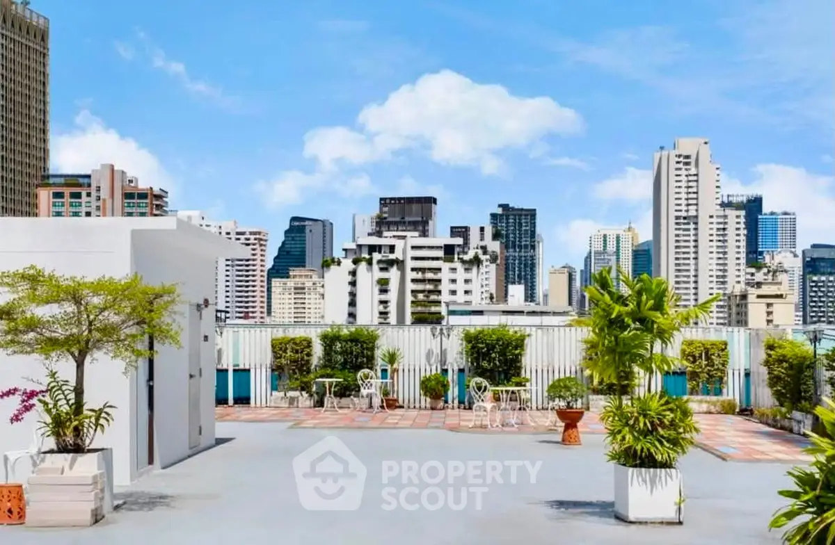 Stunning rooftop terrace with city skyline views and lush greenery.