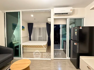 Modern studio apartment with open layout, featuring a cozy living area and sleek kitchen appliances.
