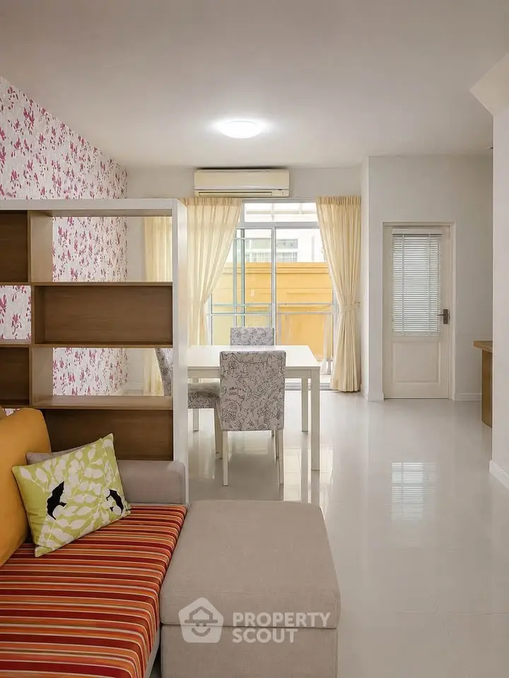 Stylish living room with modern decor and open dining area, featuring bright natural light and elegant furnishings.
