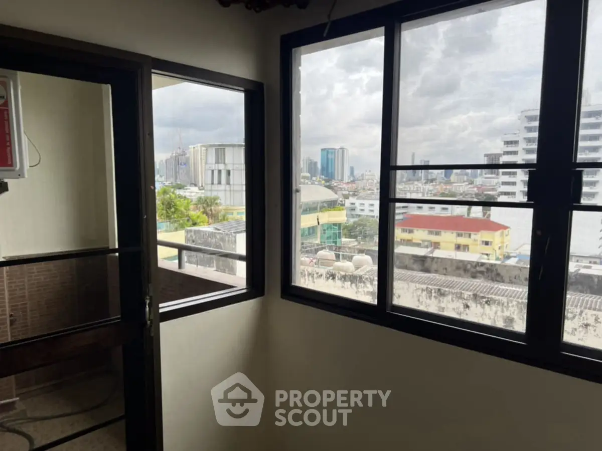 City view from a high-rise apartment window with balcony access