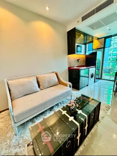Modern living room with stylish furniture and open kitchen layout in a high-rise apartment.