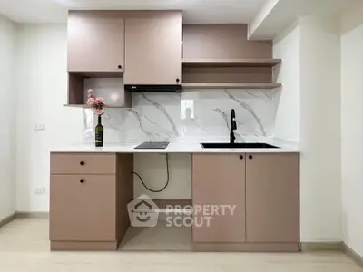 Modern kitchen with sleek cabinetry and marble backsplash, featuring a stylish open layout and elegant design.