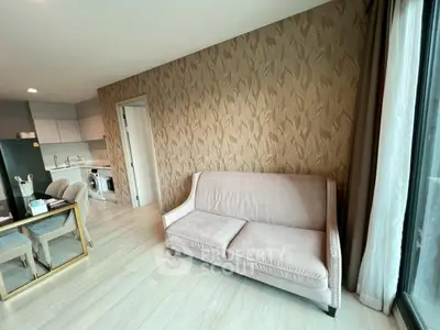 Modern living room with stylish sofa and open kitchen layout in a cozy apartment.