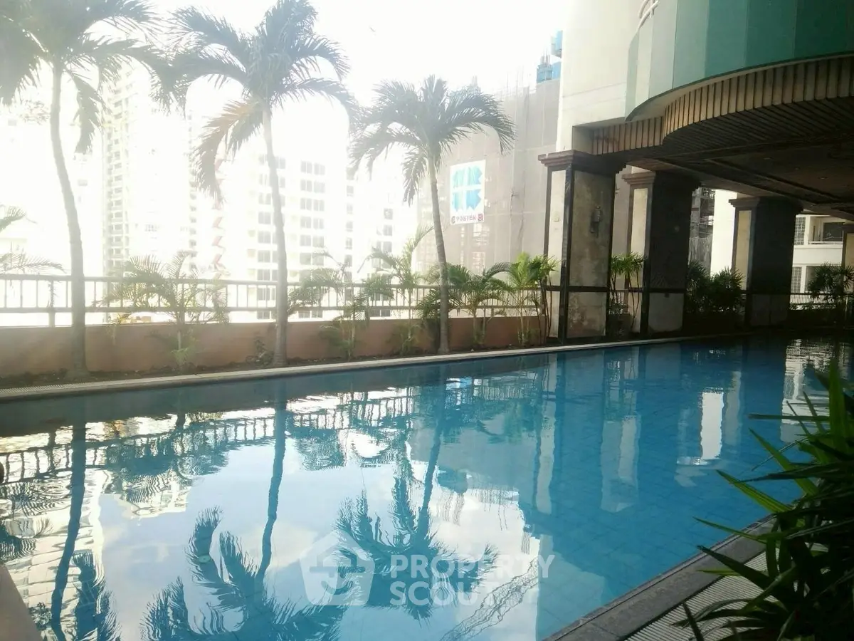 Luxurious rooftop pool with city skyline views and lush palm trees, perfect for relaxation and leisure.