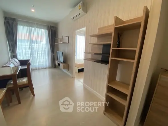 Modern living room with open layout and stylish furniture, featuring a cozy dining area and natural light.