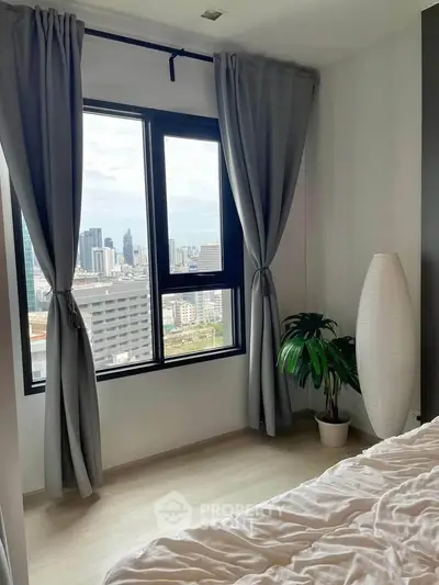 Modern bedroom with city view, featuring large window and elegant curtains, perfect for urban living.