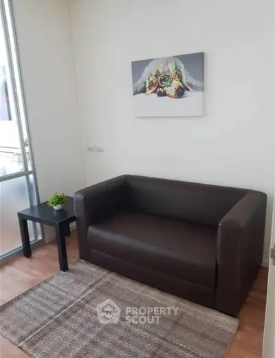 Cozy living room with modern sofa and artistic dog painting, perfect for relaxation.