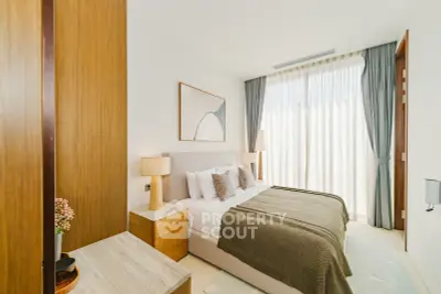 Luxurious bedroom with elegant decor and large window offering natural light