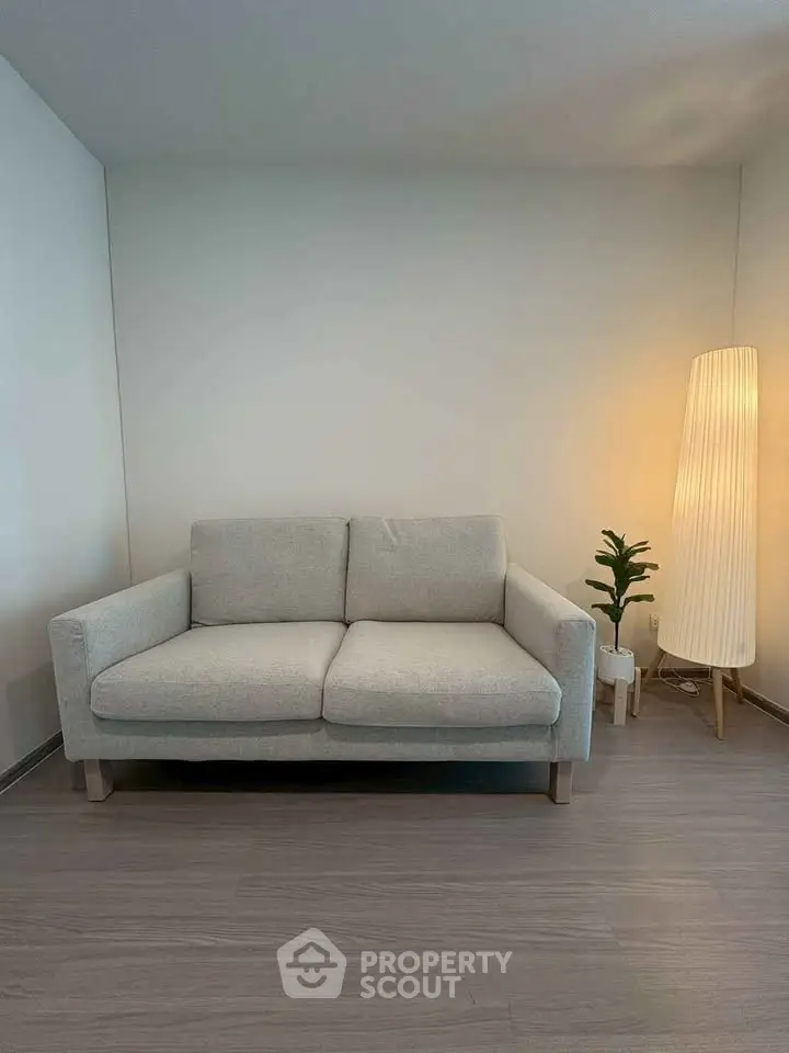 Modern minimalist living room with cozy beige sofa and stylish floor lamp.
