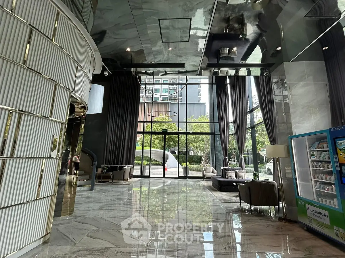 Luxurious modern building lobby with sleek design and large glass windows.