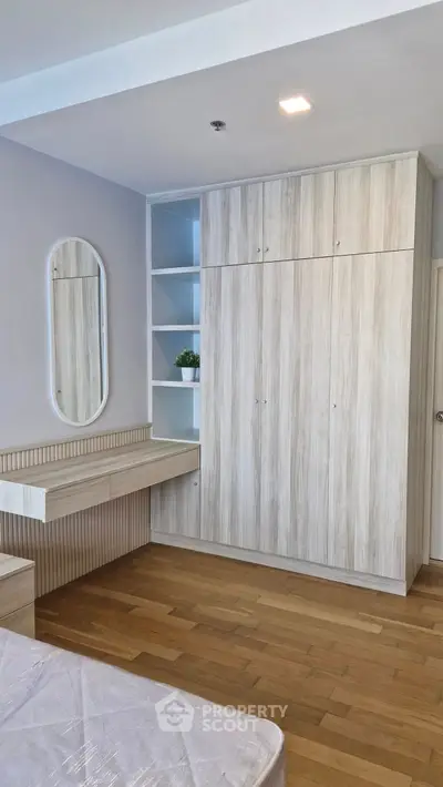 Modern bedroom with built-in wardrobe and wooden flooring