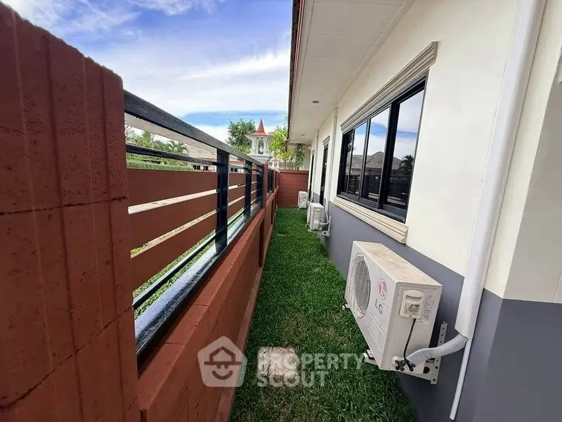 Charming exterior view of a modern home with lush green lawn and sleek air conditioning units.