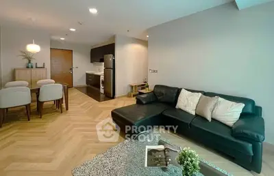 Modern living room with stylish decor and open kitchen layout in a cozy apartment.