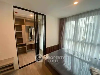 Modern bedroom with large window and mirrored closet in stylish apartment