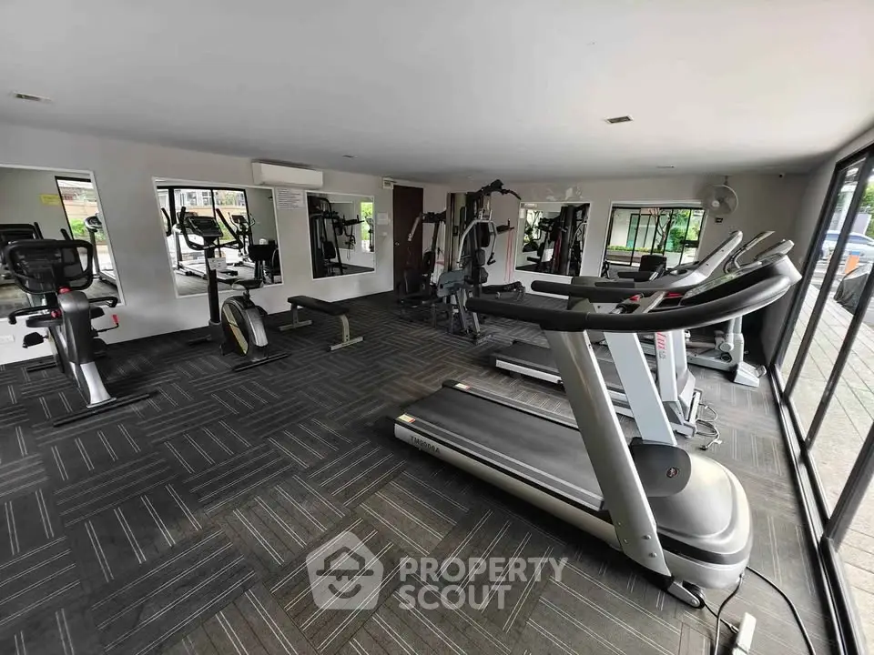Modern gym with state-of-the-art equipment and large mirrors, perfect for fitness enthusiasts.