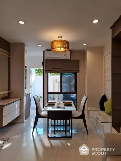 Modern dining area with elegant lighting and natural light from large window