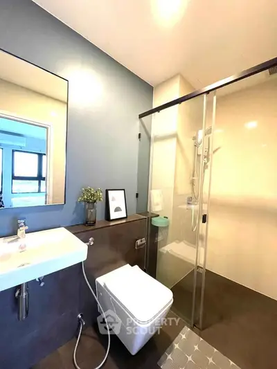 Modern bathroom with sleek design, featuring a glass shower and stylish fixtures.