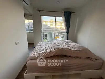 Cozy bedroom with large window and balcony view in modern apartment