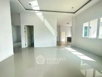 Spacious modern living room with large windows and glossy tiled floors, perfect for natural light lovers.