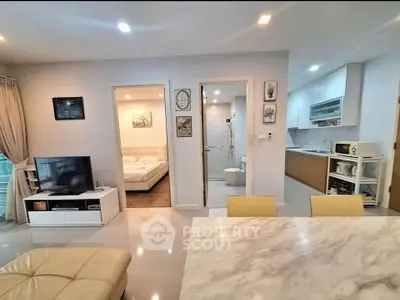 Modern open-plan living area with kitchen and bedroom view
